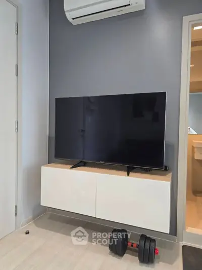 Modern living room with sleek TV setup and air conditioning, perfect for comfortable living.