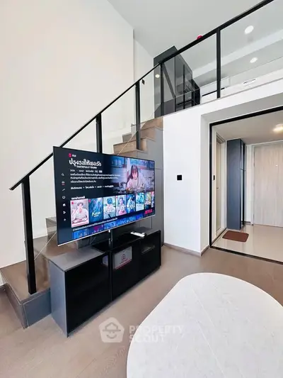 Modern duplex living room with sleek staircase and entertainment setup