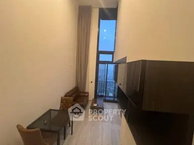 Spacious living room with high ceilings and modern furniture, offering a stunning city view.