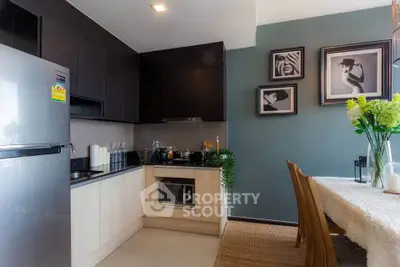 Modern kitchen with sleek cabinets and dining area, featuring stylish decor and ample natural light.