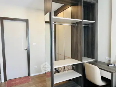Modern bedroom with built-in wardrobe and study desk, featuring sleek wood finishes and ample storage space.
