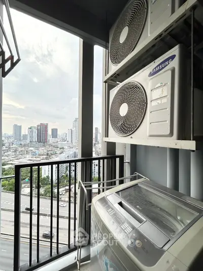 High-rise balcony with city view, featuring air conditioning units and washing machine.