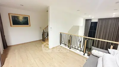Spacious modern living area with elegant staircase and large windows