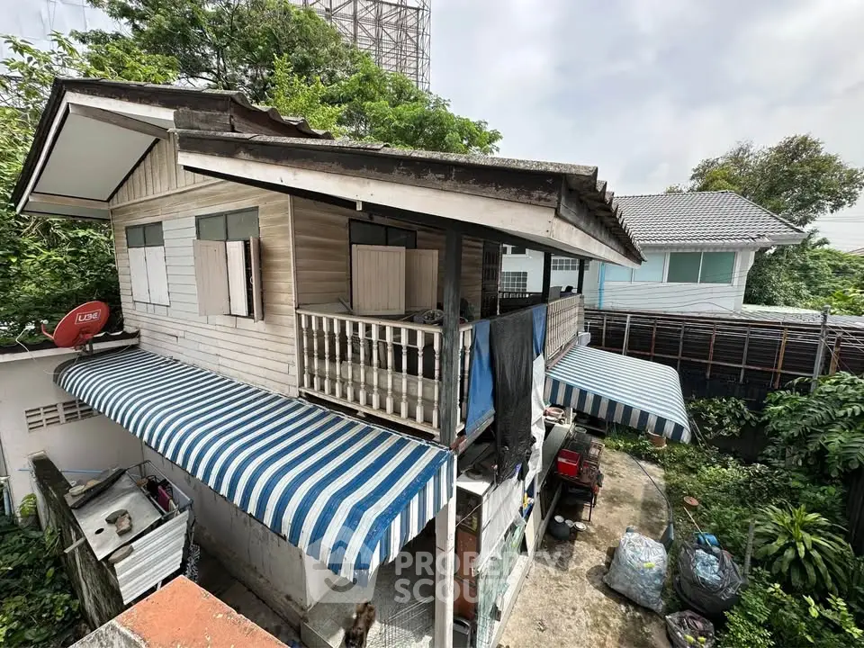 Charming rustic wooden house with striped awnings and lush greenery, perfect for a serene lifestyle.