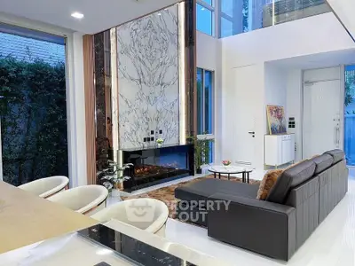 Luxurious modern living room with high ceilings, marble fireplace, and elegant decor