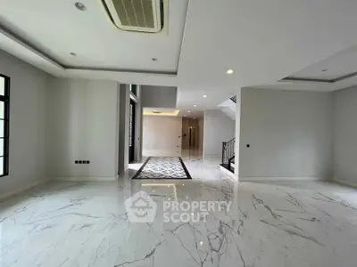 Spacious modern living room with marble flooring and elegant staircase