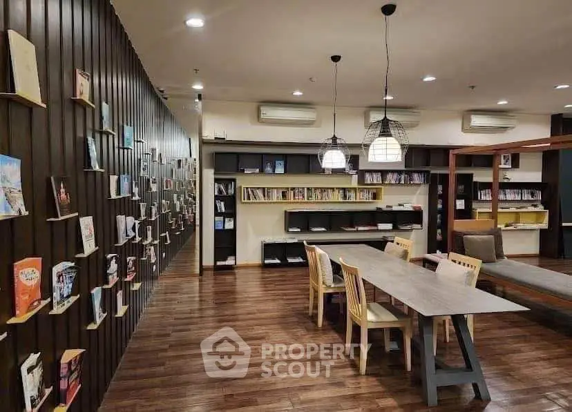 Modern library with stylish wooden flooring and cozy reading area in a residential building.