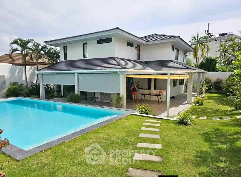 Luxurious modern house with pool and lush garden, perfect for serene living.