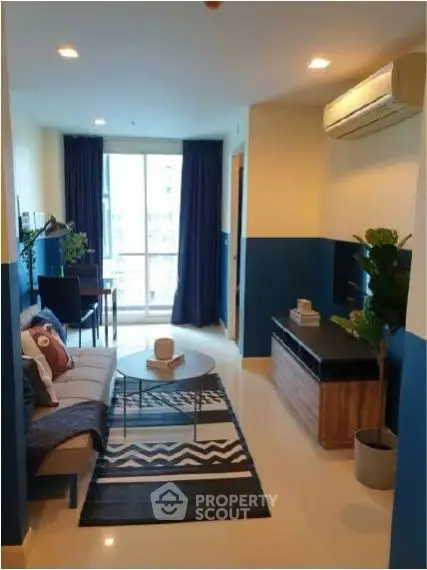 Modern living room with stylish decor and natural light, featuring a cozy sofa and sleek entertainment unit.