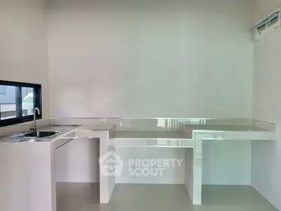 Modern minimalist kitchen with sleek countertops and built-in sink