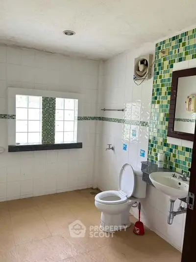 Spacious bathroom with modern fixtures and large window for natural light.