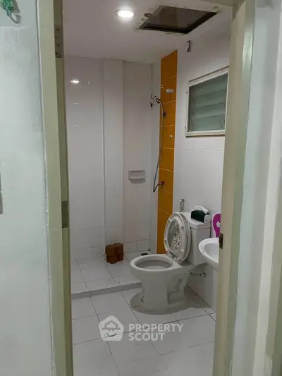 Modern bathroom with white tiles and shower in a real estate property.