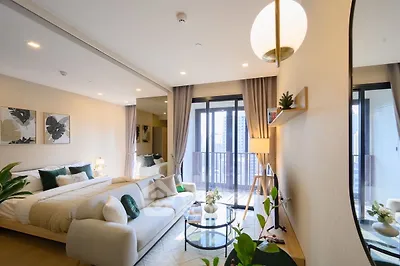 Luxurious modern bedroom with balcony and stylish decor in high-rise apartment.