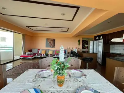 Spacious living room with open kitchen and dining area, featuring modern decor and ample natural light.