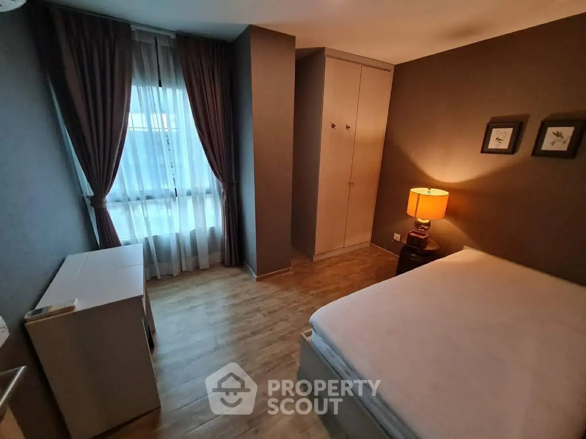 Cozy bedroom with wooden flooring and ambient lighting in modern apartment