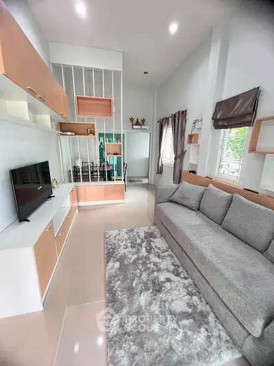 Modern living room with sleek furniture and large windows for natural light.