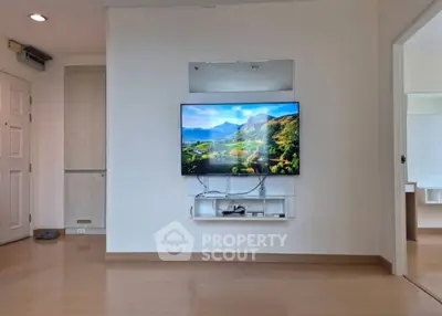Modern living room with wall-mounted TV and sleek wooden flooring