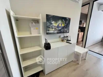 Modern living room with sleek white furniture and wall-mounted TV, showcasing contemporary design.