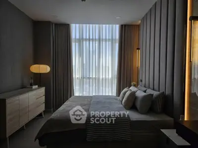 Luxurious bedroom with modern decor and large window offering natural light.