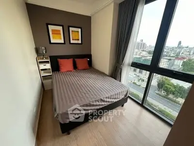 Modern bedroom with large window offering city view, featuring stylish decor and cozy ambiance.