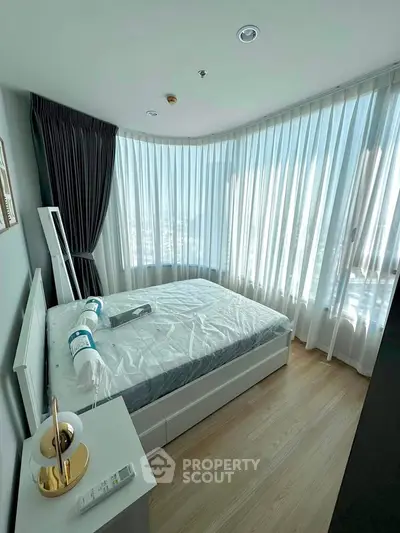 Modern bedroom with large windows and elegant decor in a high-rise apartment.