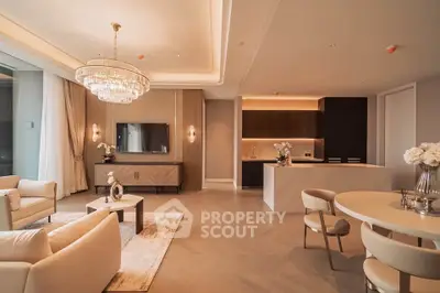 Luxurious open-plan living room with elegant chandelier and modern kitchen