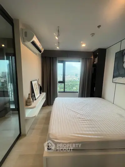 Modern bedroom with large window offering stunning city view, featuring minimalist decor and air conditioning.