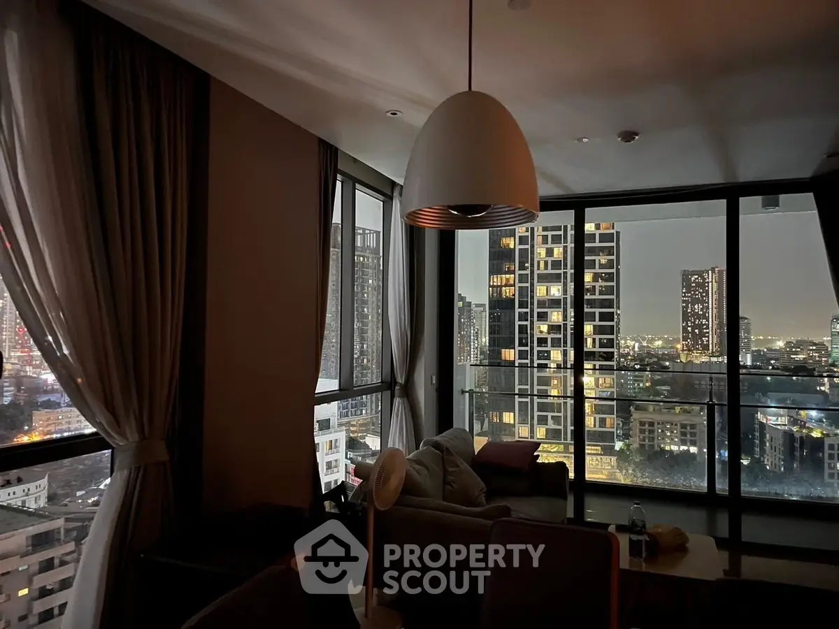 Stunning city view from modern living room with floor-to-ceiling windows and elegant decor.