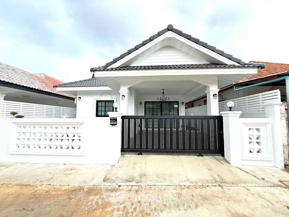 Charming single-story white house with modern gate and inviting facade