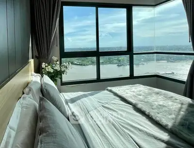 Luxurious bedroom with stunning river view from corner window, elegant decor and plush bedding.