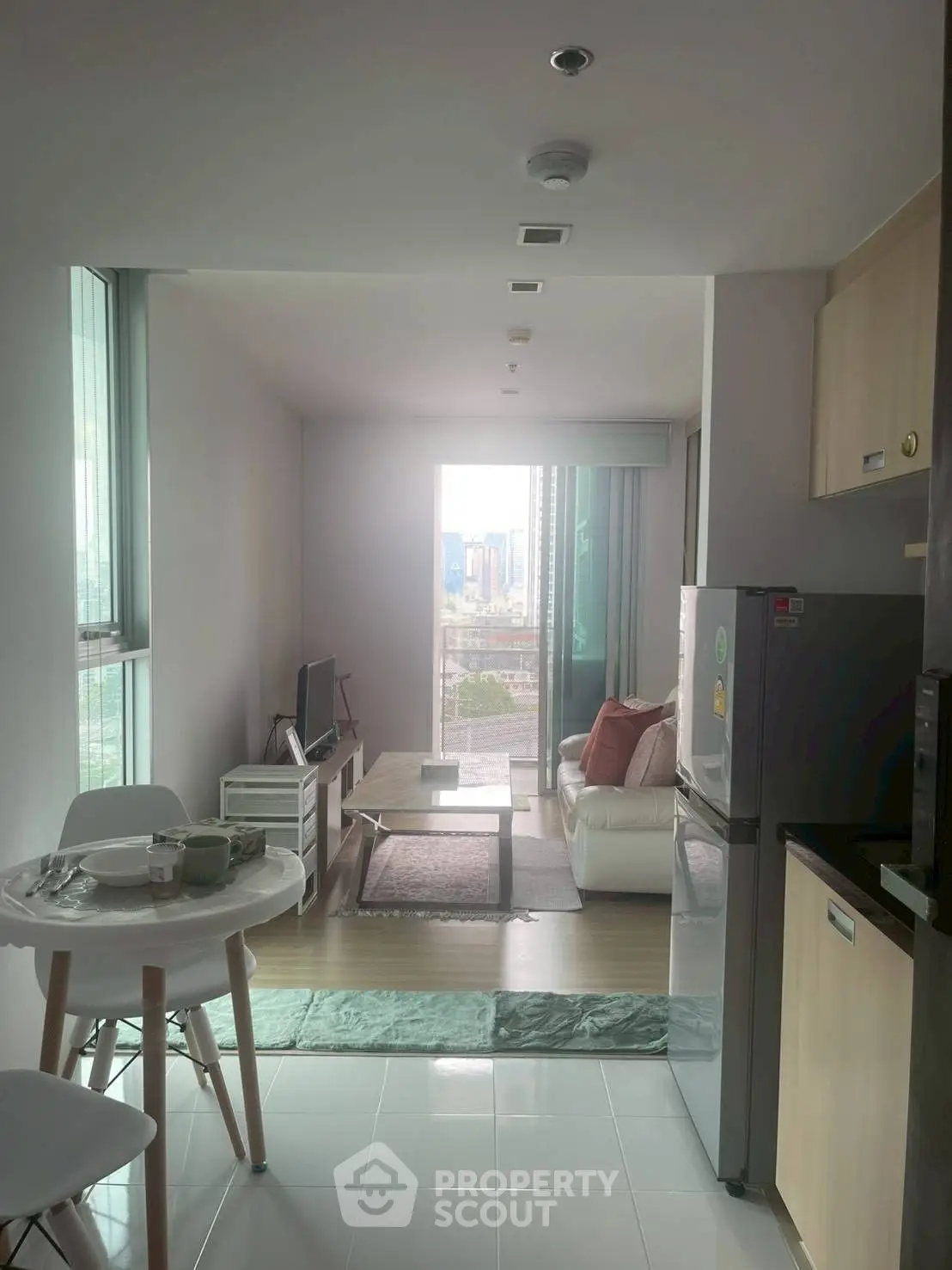 Modern living room with city view, featuring sleek furniture and open layout, perfect for urban living.