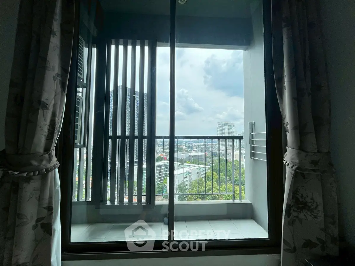 Stunning city view from a modern apartment balcony with elegant curtains.