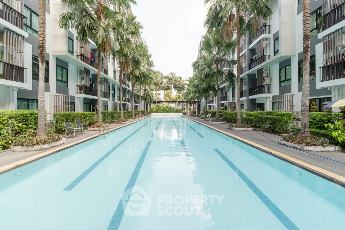 Luxurious apartment complex with a stunning outdoor pool and lush palm trees.