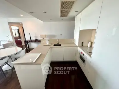 Modern kitchen with sleek white cabinetry and integrated appliances in open layout