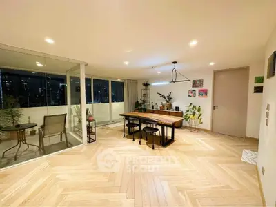 Spacious modern living room with elegant dining area and large balcony offering stunning city views.