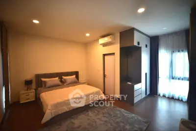 Spacious modern bedroom with stylish decor and ample natural light