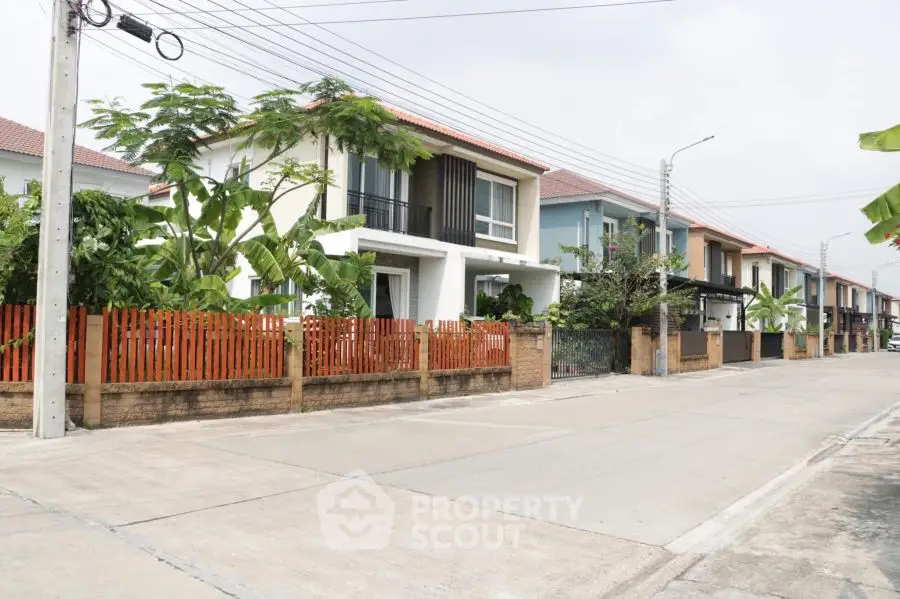 Charming suburban street with modern two-story homes and lush greenery.