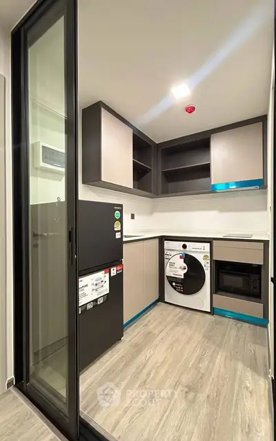 Modern kitchen with sleek cabinetry, built-in appliances, and sliding glass door for space efficiency.