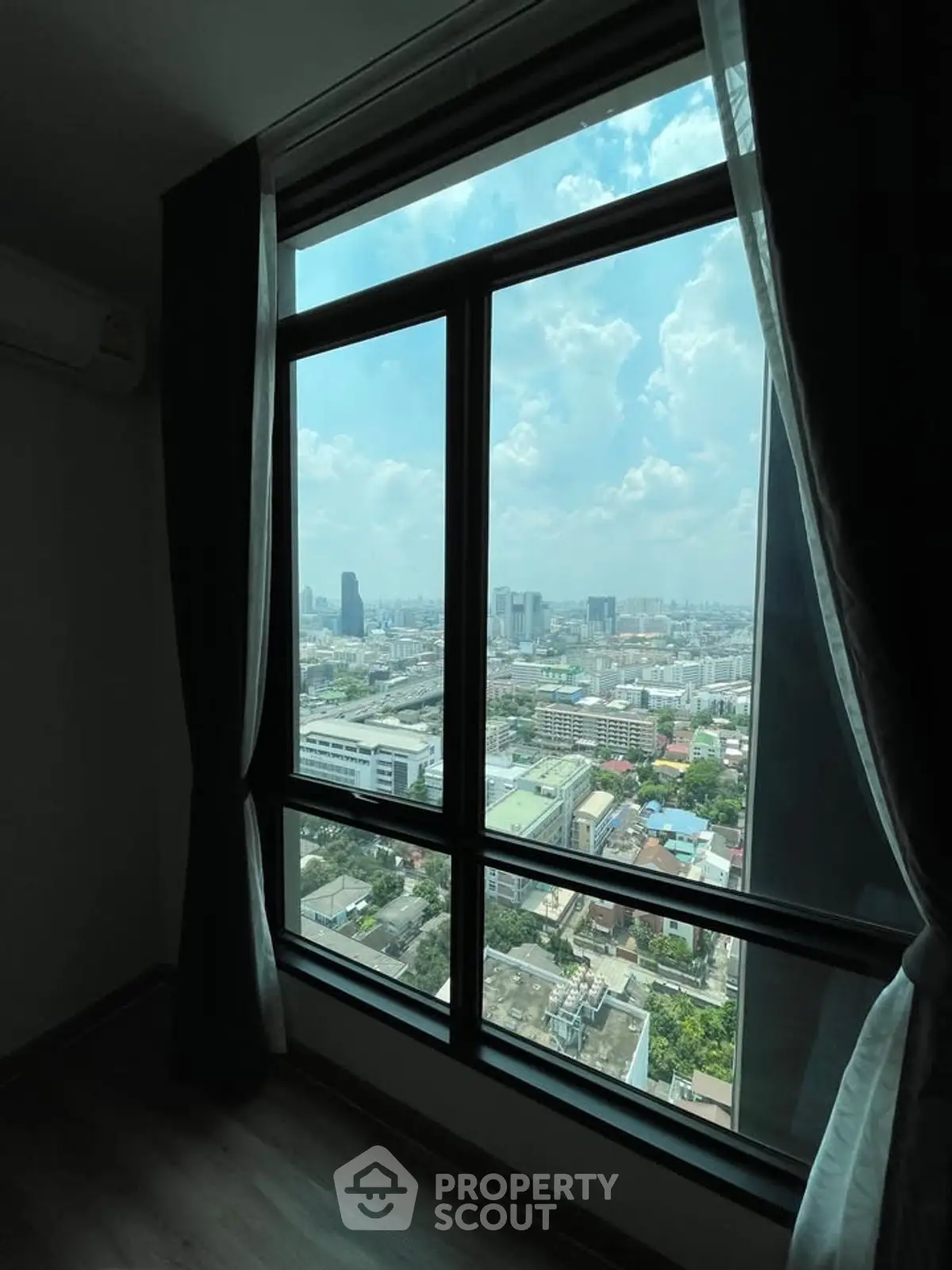 Stunning high-rise city view from a modern apartment window, showcasing urban skyline.