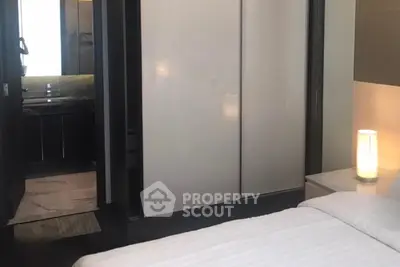Modern bedroom with ensuite bathroom and sleek sliding closet doors.