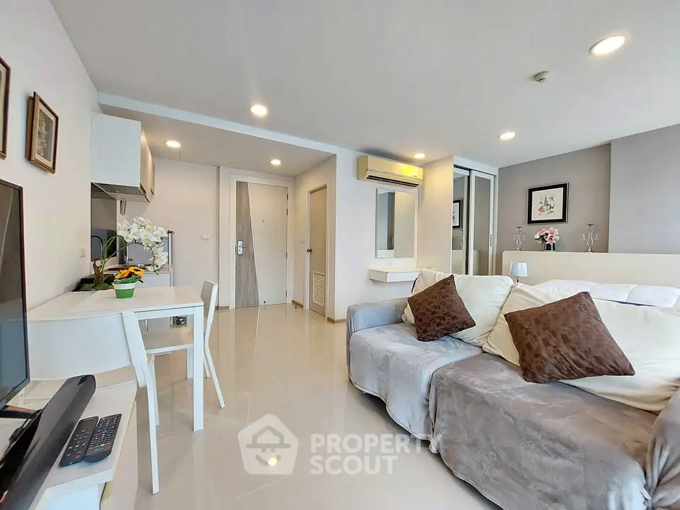 Modern living room with cozy sofa and dining area in open layout apartment.