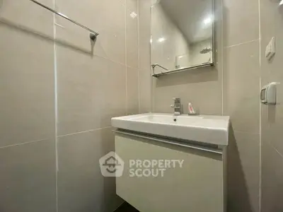 Modern bathroom with sleek sink and mirror in a contemporary apartment.