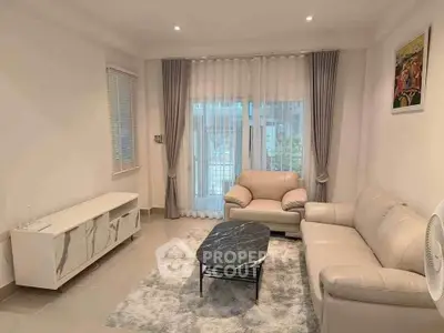 Elegant living room with modern furniture and large window, perfect for relaxation.
