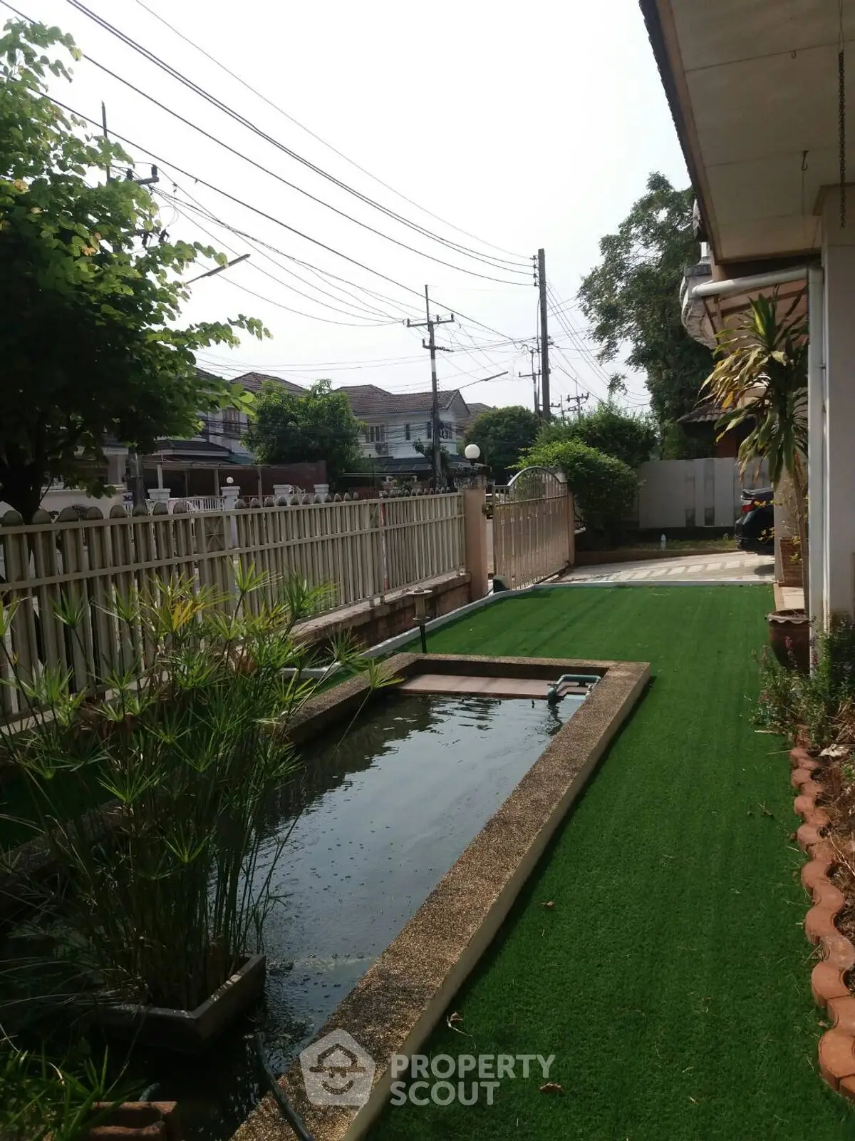 Charming garden with lush greenery and serene water feature in a residential property.