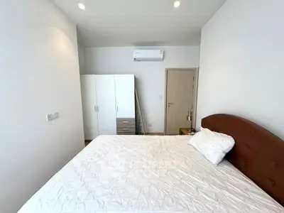 Spacious bedroom with modern furnishings and air conditioning in a stylish apartment.