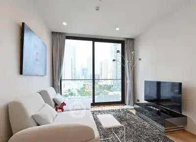 Modern living room with city view, sleek furniture, and large window in urban apartment.