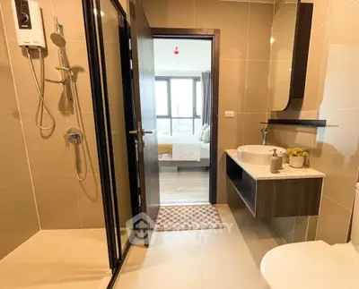 Modern bathroom with shower and view into bedroom, sleek design and neutral tones.