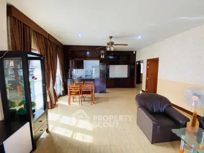 Spacious living room with elegant wooden furniture and large windows for natural light.