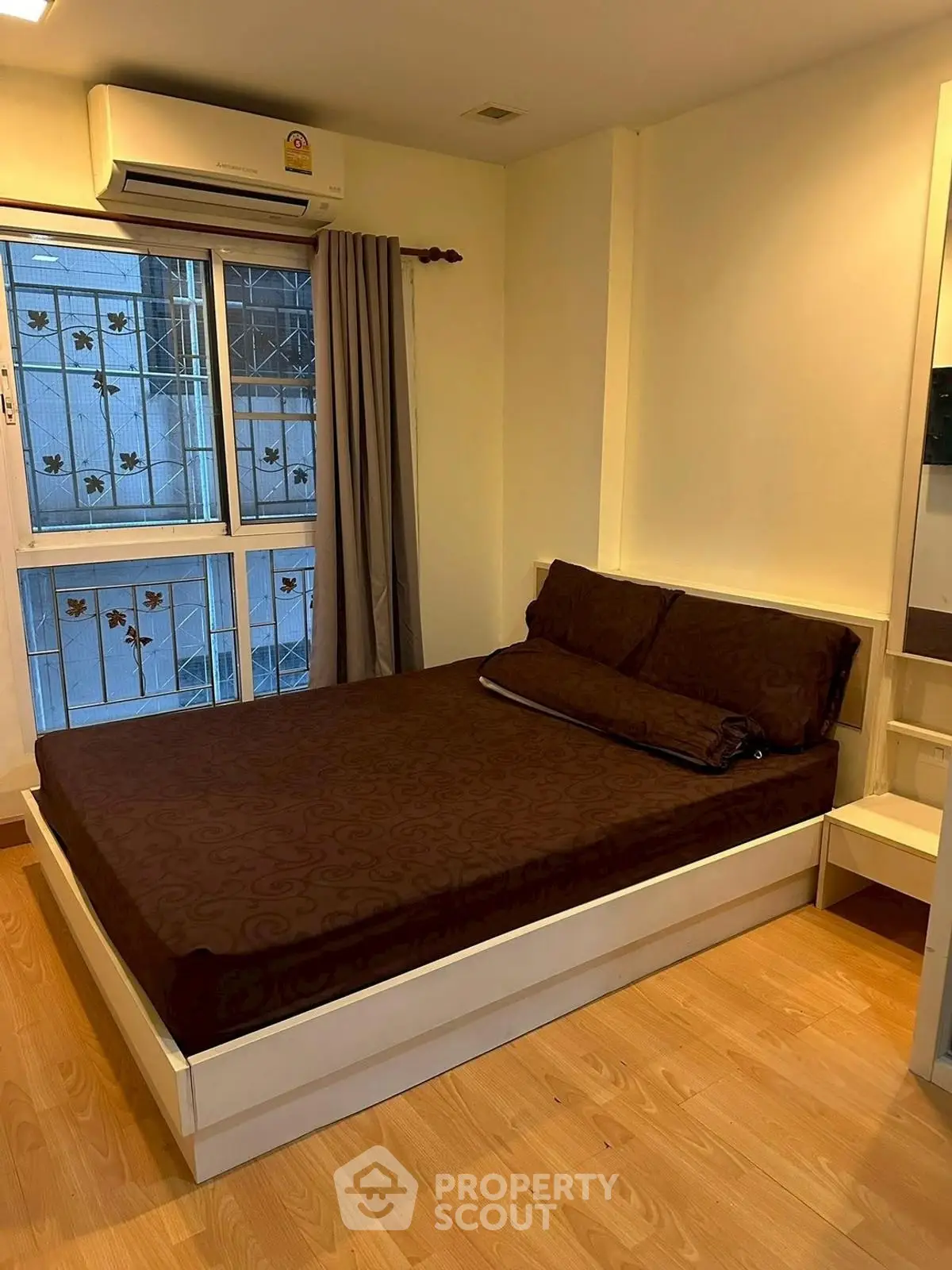 Cozy bedroom with brown bedding and natural light from window