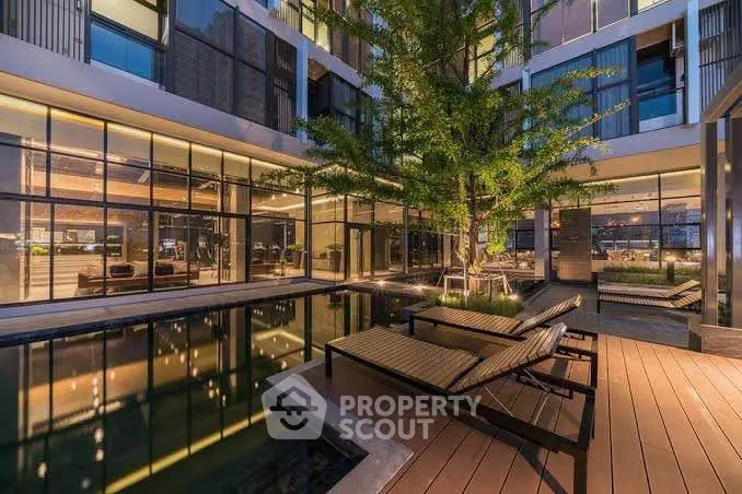 Luxurious modern building with serene poolside and elegant wooden deck.